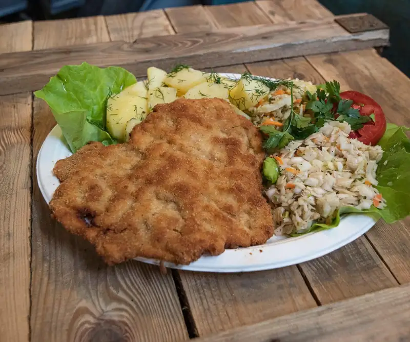 Kotlet z kaszą i surówką na drewnianym stole